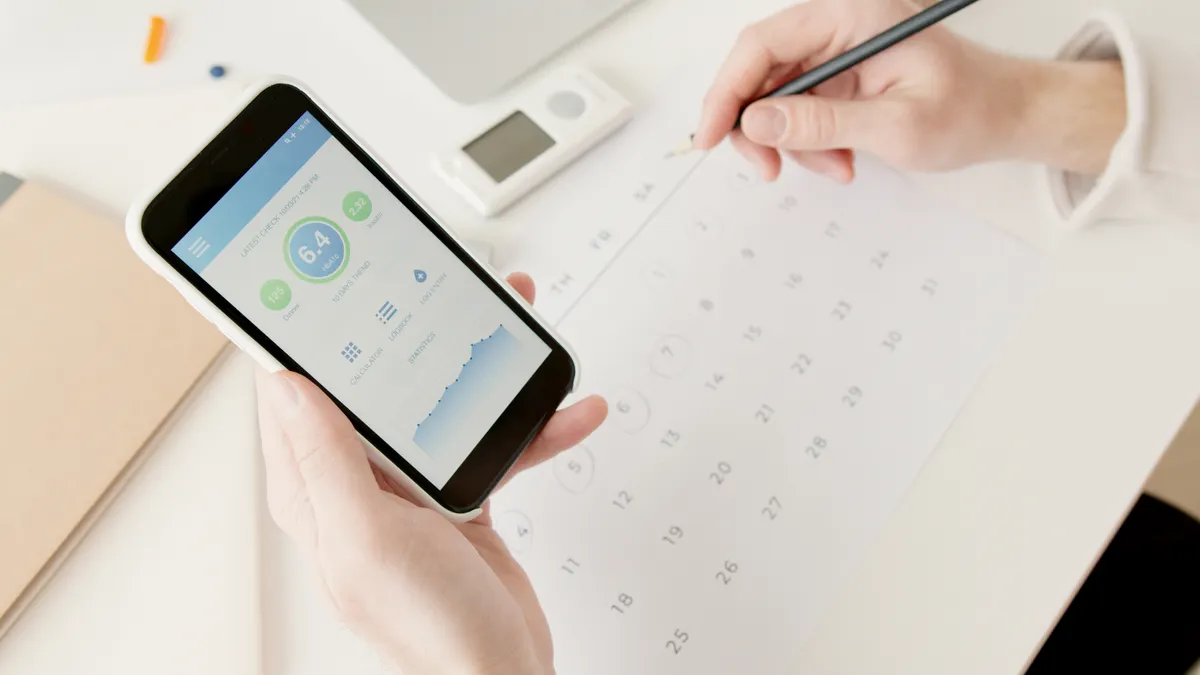 Smartphone and paper calendar for scheduling appointments