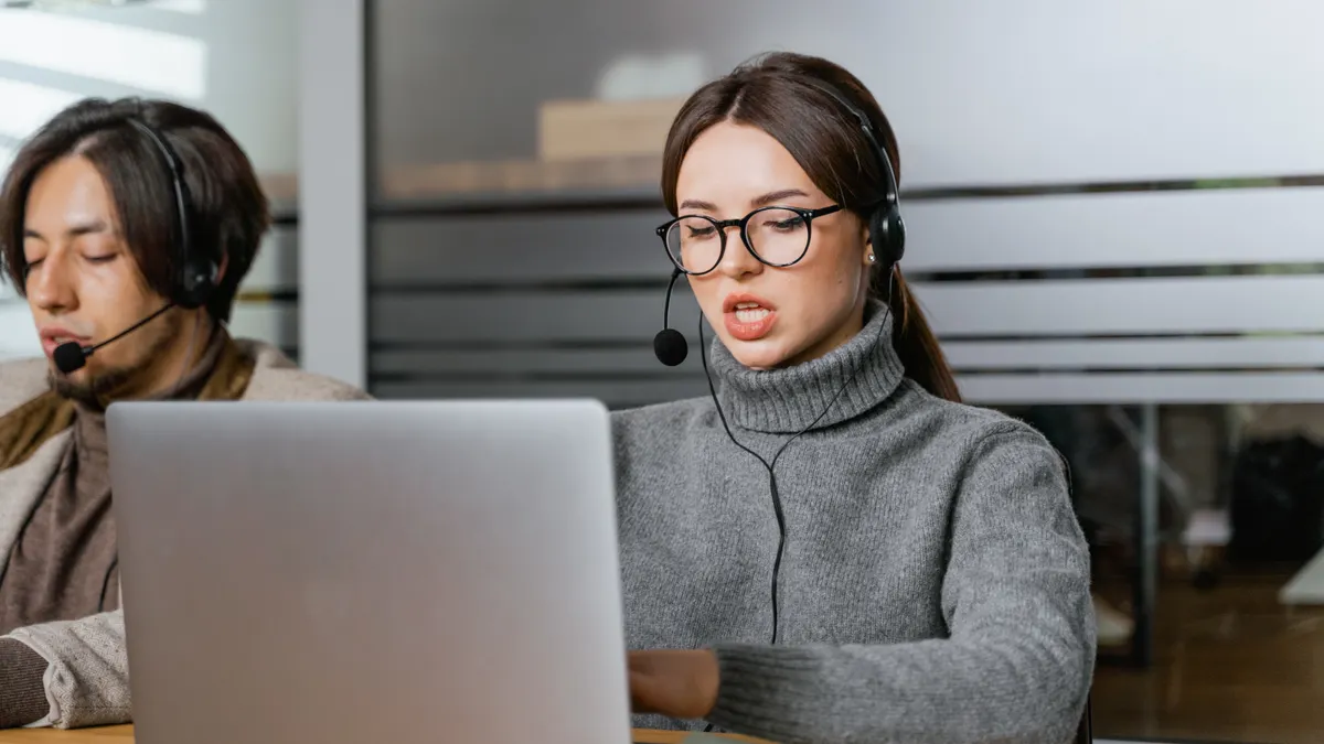AI chatbot pricing: what website owners should budget for two office workers using a laptop with headsets