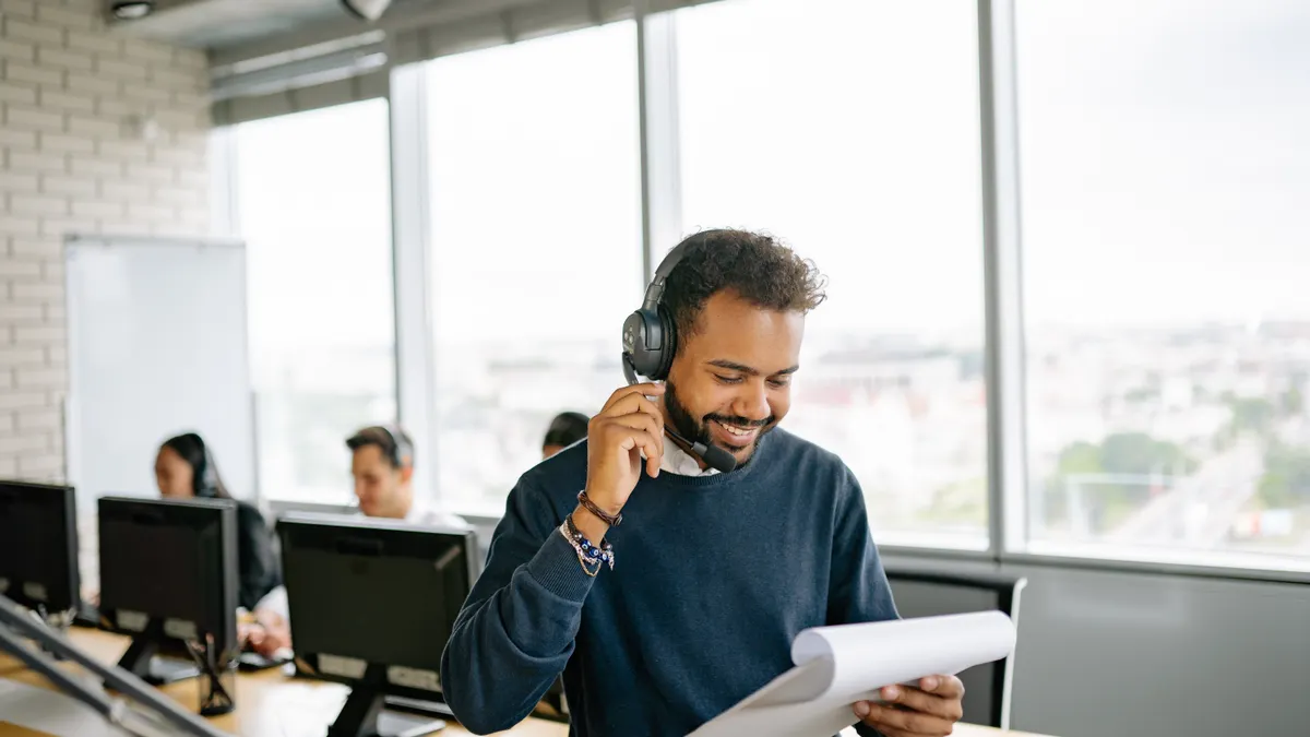 AI chatbot pricing: what website owners should budget for man in office reading papers while wearing a headset